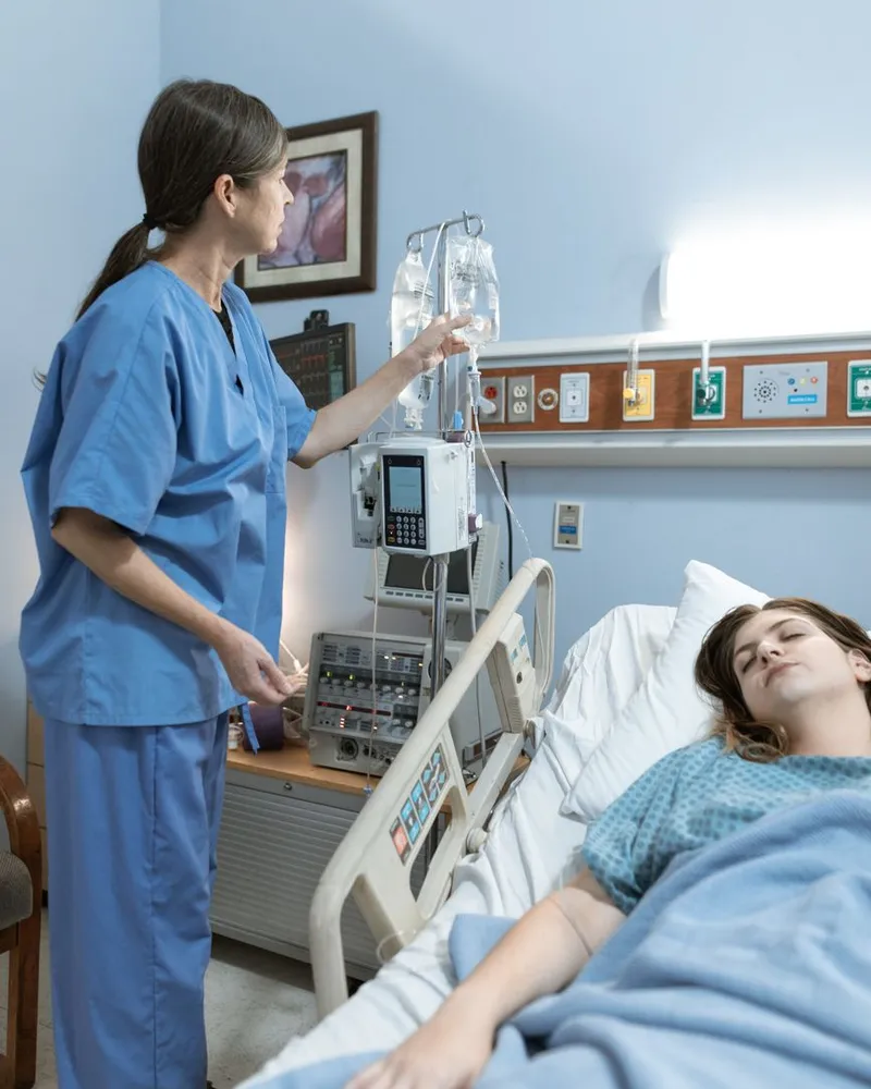 Infermiera che assiste una paziente in una stanza d'ospedale
