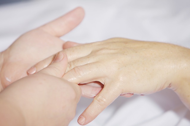 Reumatologo che esamina le mani di una paziente