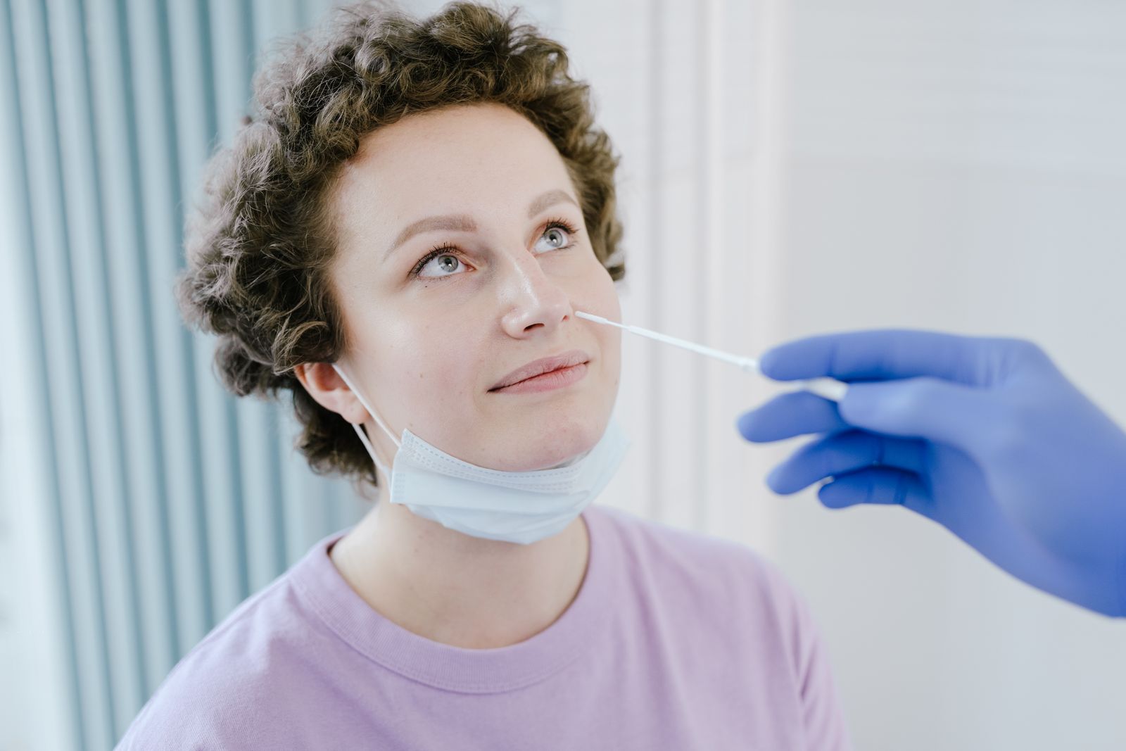 Operatore sanitario con dispositivi di protezione che esegue un tampone