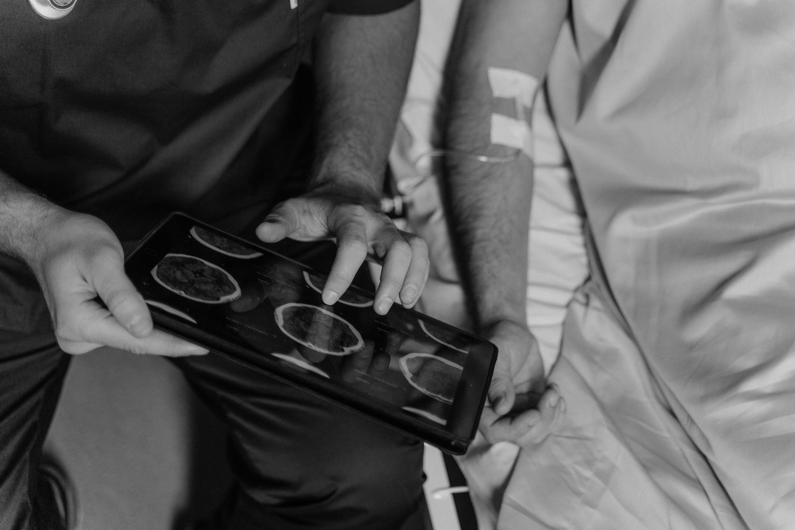 Medico che osserva immagini diagnostiche del cervello e un tracciato cardiaco