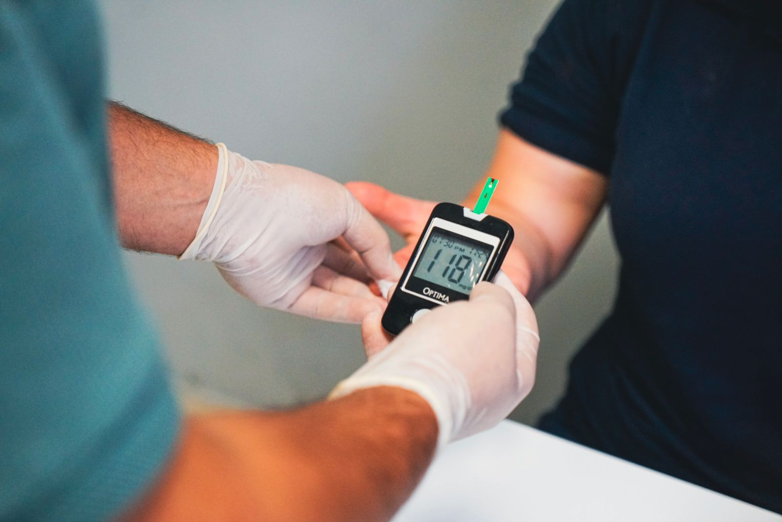 Medico che controlla la glicemia di un paziente con il glucometro